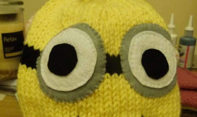 Securely sew the felt eyes onto the black band on the Minion hat